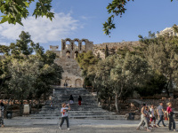 tourists going past the stairs, where lead up to the herodes atticus theatre in athens