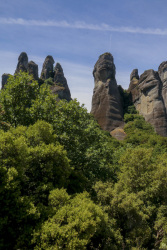 green trees, mystic hills and a blue sky in meteora in the north of greece