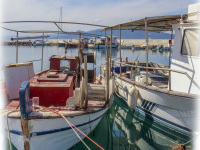two fisherboats are laying in the harbor of arkitsa