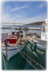two fisherboats are laying in the harbor of arkitsa