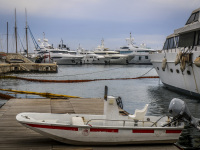 in front of big yachts is laying a little motorboat wich is signed with \"Olympiacos piraeus FC\"
