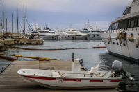 in front of big yachts is laying a little motorboat wich is signed with \"Olympiacos piraeus FC\"