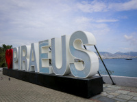 the piraeus sign with the big lettering \"Piraeus\" and a red heart at the harbor