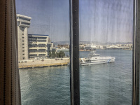 view through a shipwindow to the harbour of piraeus with white houses