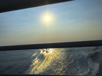 on the way to greek islands with a view from a shiprailing on the wake and on the sun, that reflects in the ocean
