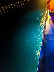 while a nightly trip to rhodes there is a illuminated shiprailing and the turquoise sea